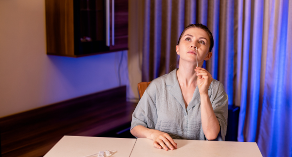 Image of person testing themselves with a COVID-19 PCR home test kit