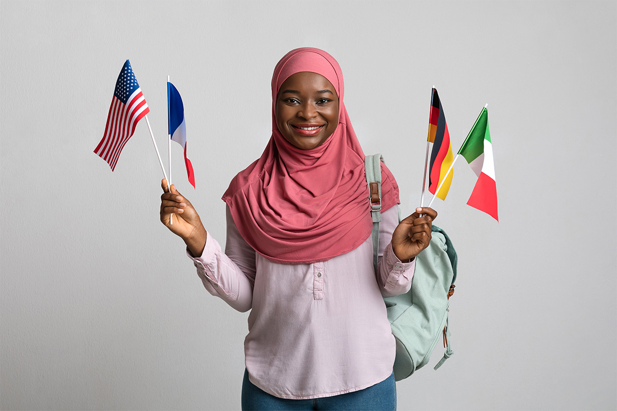 An Ad Astra translator joyfully holds the flags of several countries.
