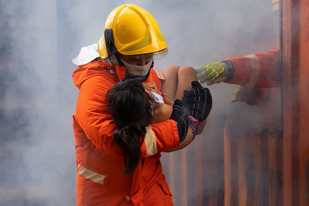 An emergency worker rescues a child in a disaster