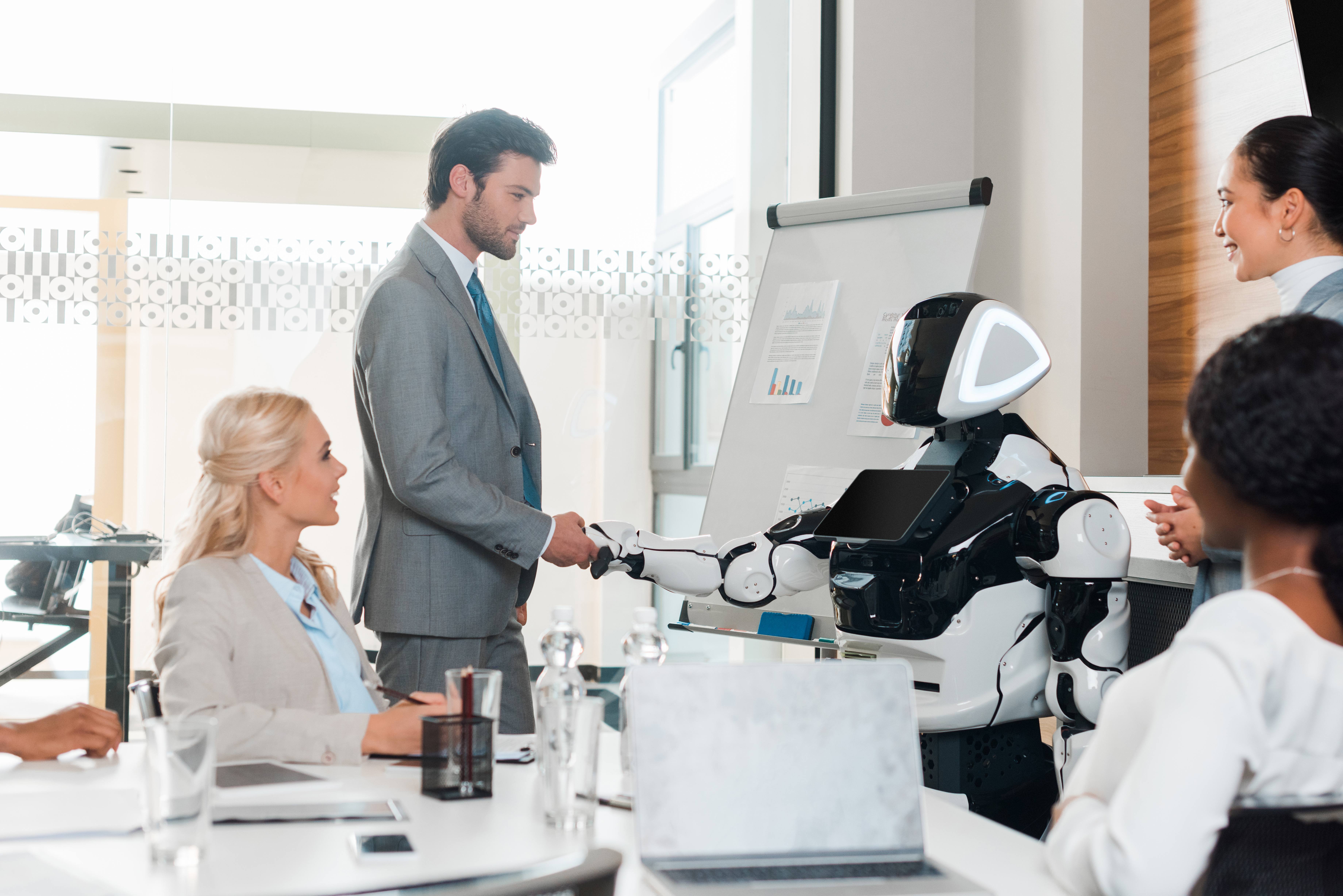 handsome-businessman-shaking-hands-with-robot-near-2024-11-17-09-38-19-utc