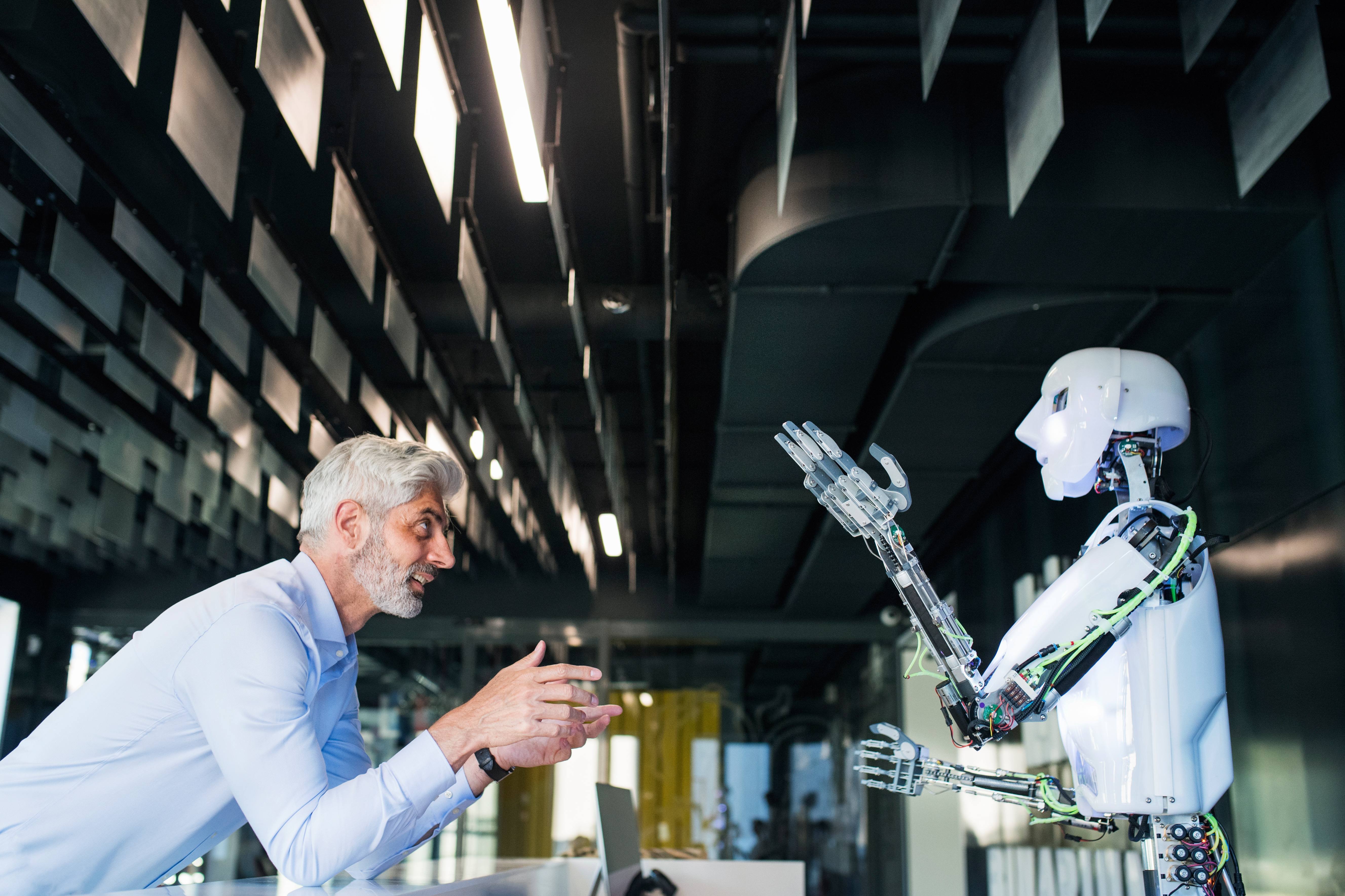 mature-businessman-or-a-scientist-with-robot-2024-10-21-05-07-58-utc