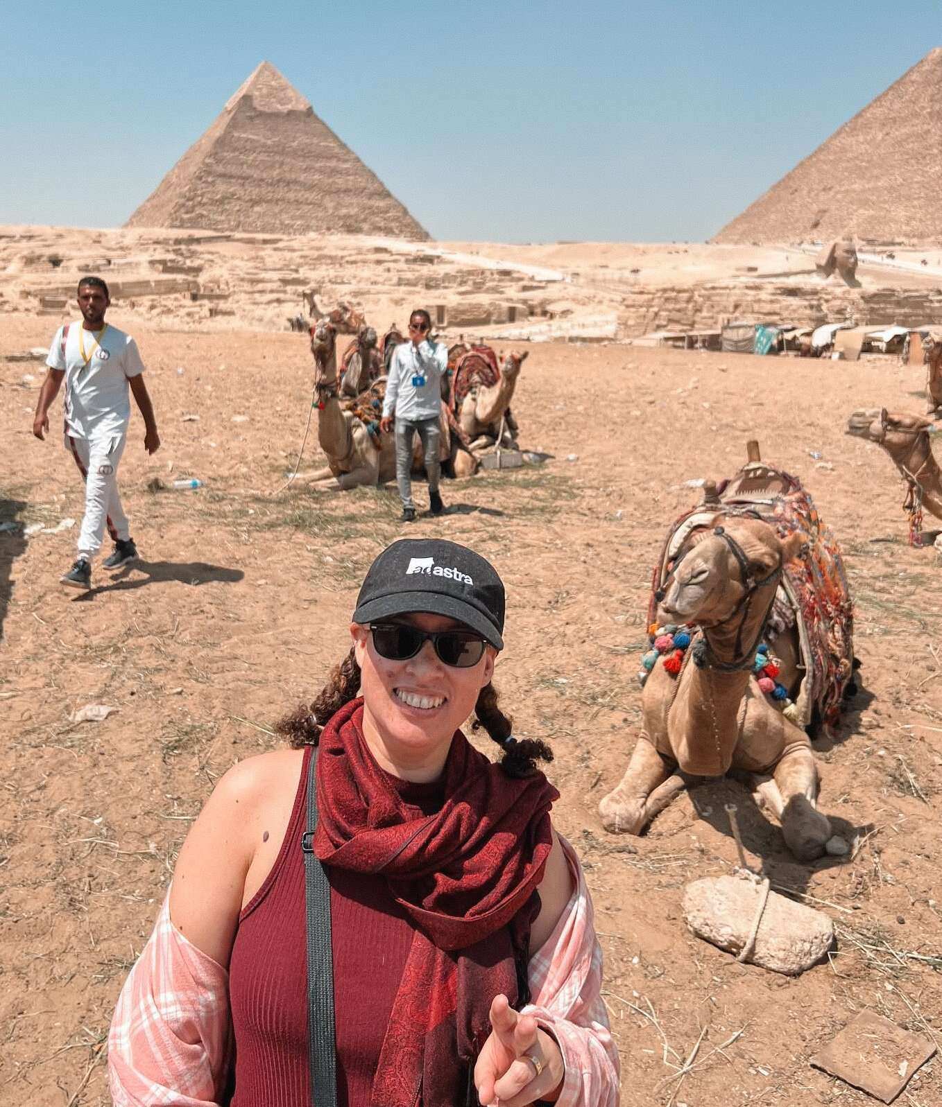 A woman taking a photo in front of the pyramids